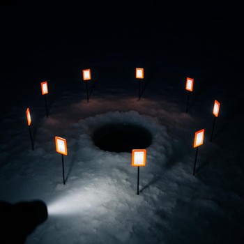 Headlamp beam revealing reflective markers around an ice hole