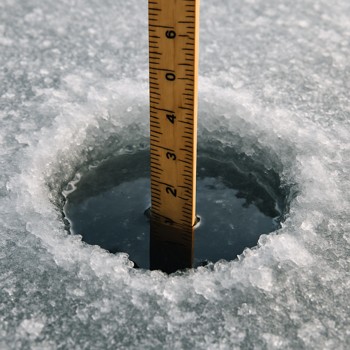 Ruler dropped into an ice hole to check total ice thickness