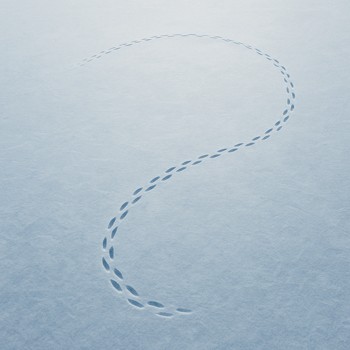 Curved trail of footprints forming a loop across a frozen lake