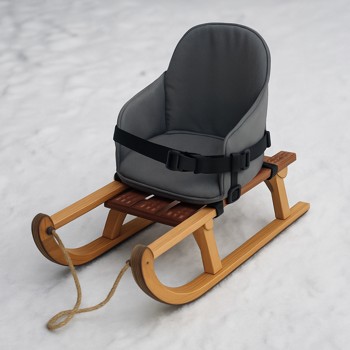 Small winter sled with a bucket seat strapped inside