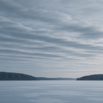 Soft layered winter clouds drifting above a frozen lake